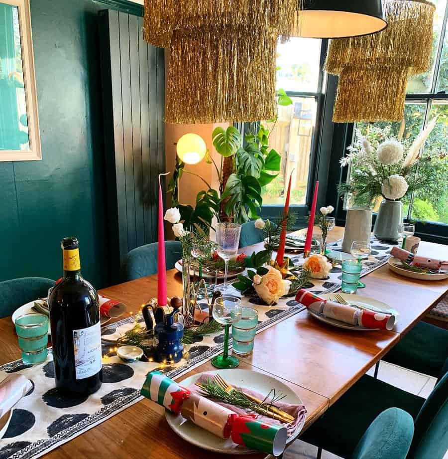 Festive dining table setup with decorations, wine, and green and white tableware