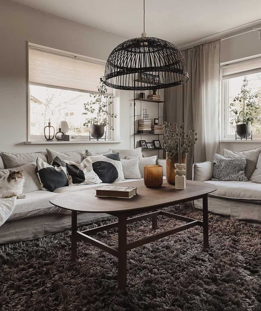 Cozy living room with a wooden table, gray sofas, and a wicker light fixture