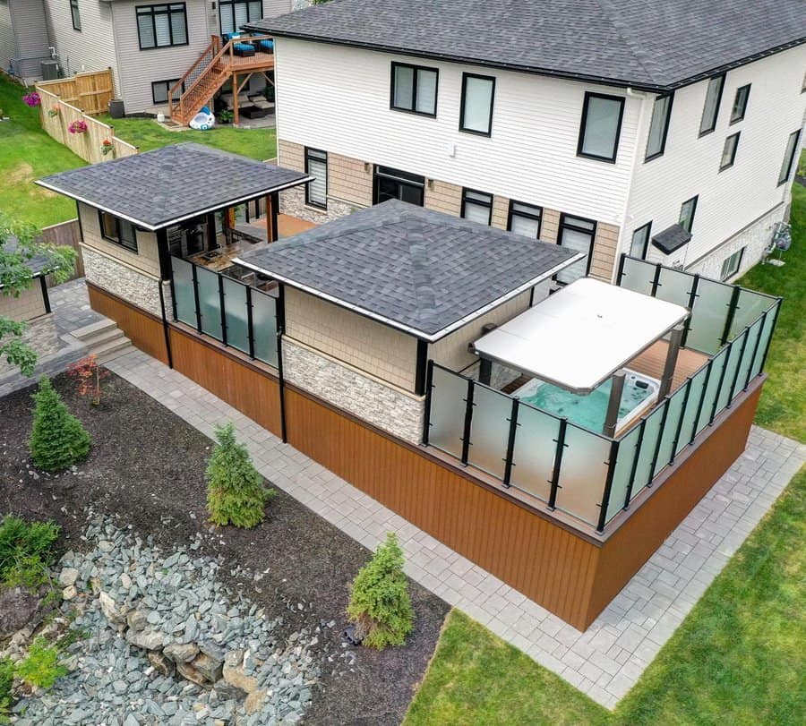 Aerial view of a modern deck with a hot tub and glass railing