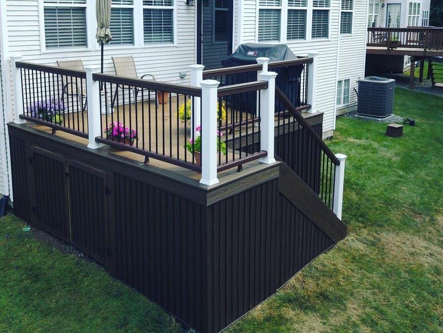 Deck with white railing and dark skirting