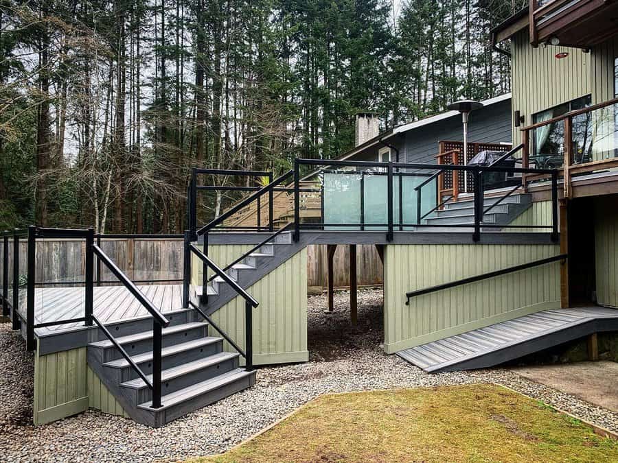 Modern deck with black railing and forest backdrop