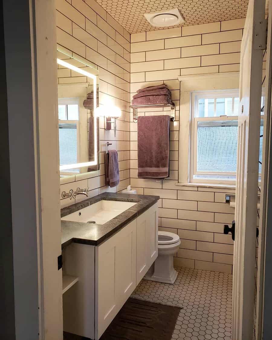 Cozy bathroom with a honeycomb tile ceiling, subway tile walls, and warm lighting, creating a vintage-inspired yet modern aesthetic.