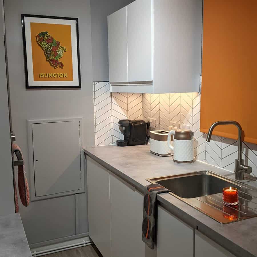 white galley kitchen with a pop of orange