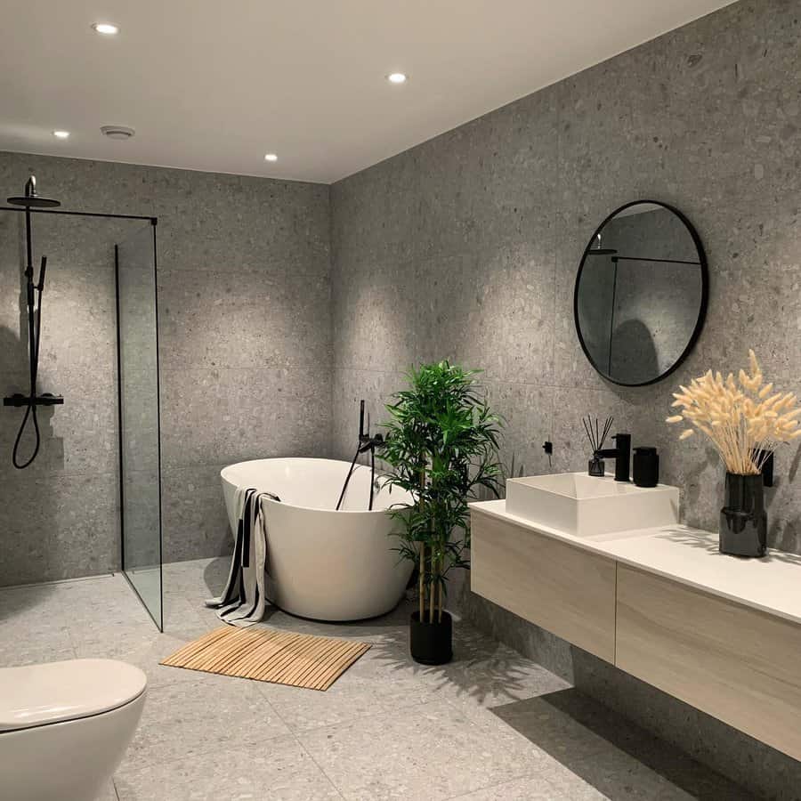 Modern gray bathroom with freestanding tub and greenery