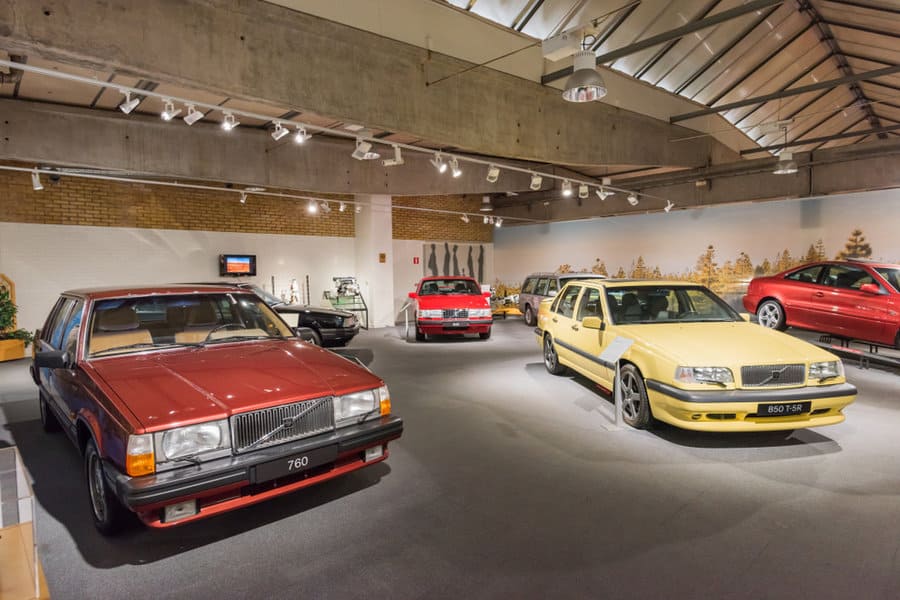 Classic car collection displayed under track lighting