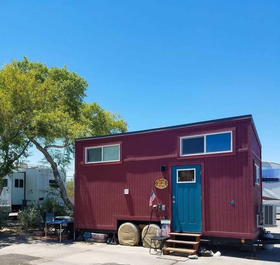 Red tiny house on wheels with blue door