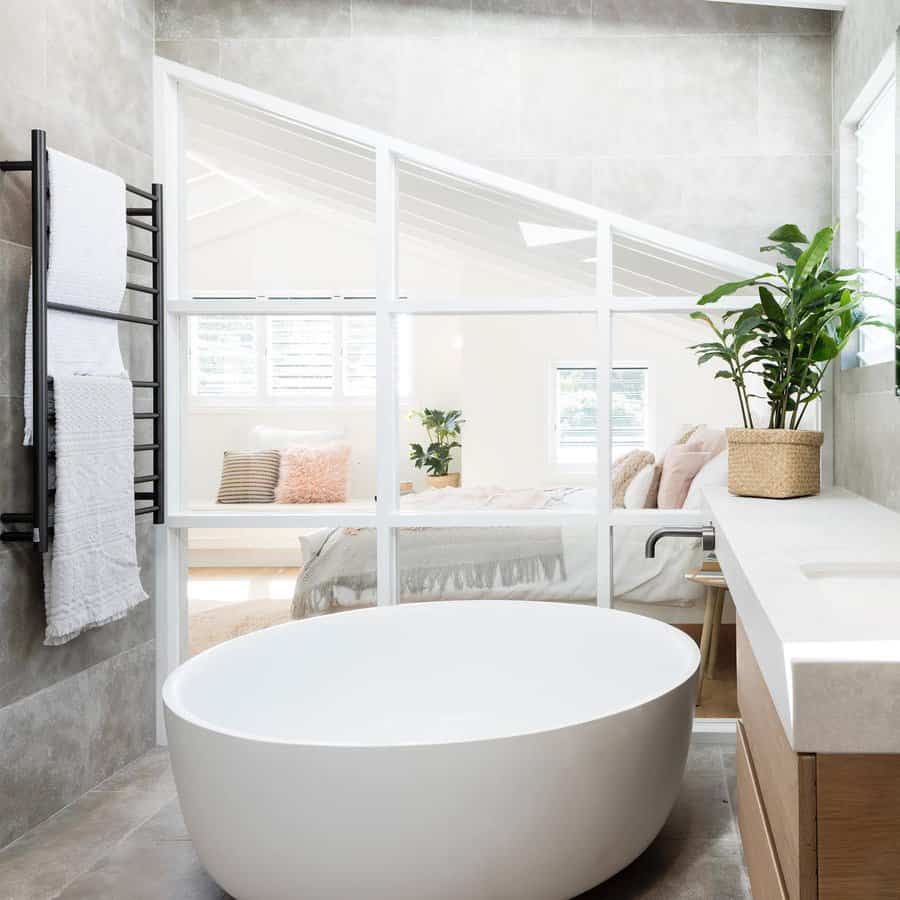 Open bathroom with oval tub and glass partitions