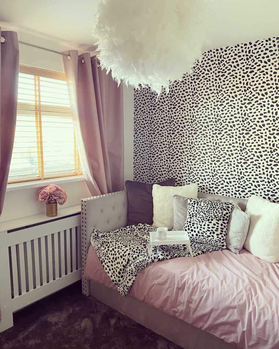 Chic upholstered daybed with tufted details, pink bedding, and leopard-print accents, creating a stylish and cozy bedroom retreat