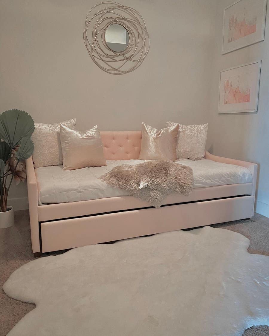 Elegant blush pink upholstered daybed with a tufted back, shimmering pillows, and a cozy faux fur throw, creating a chic and inviting space