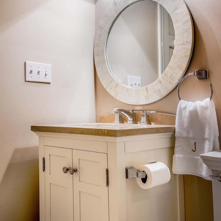 beige bathroom with neutral framed mirror and natural stone vanity 