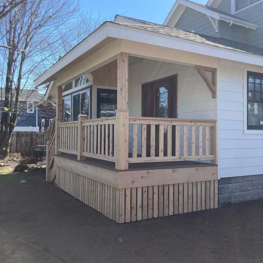 Front porch with wooden railings and vertical skirting