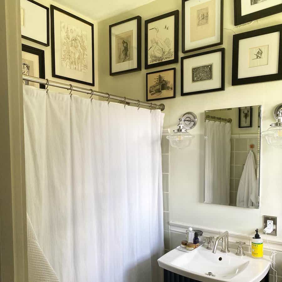 framed sketches on white bathroom wall 