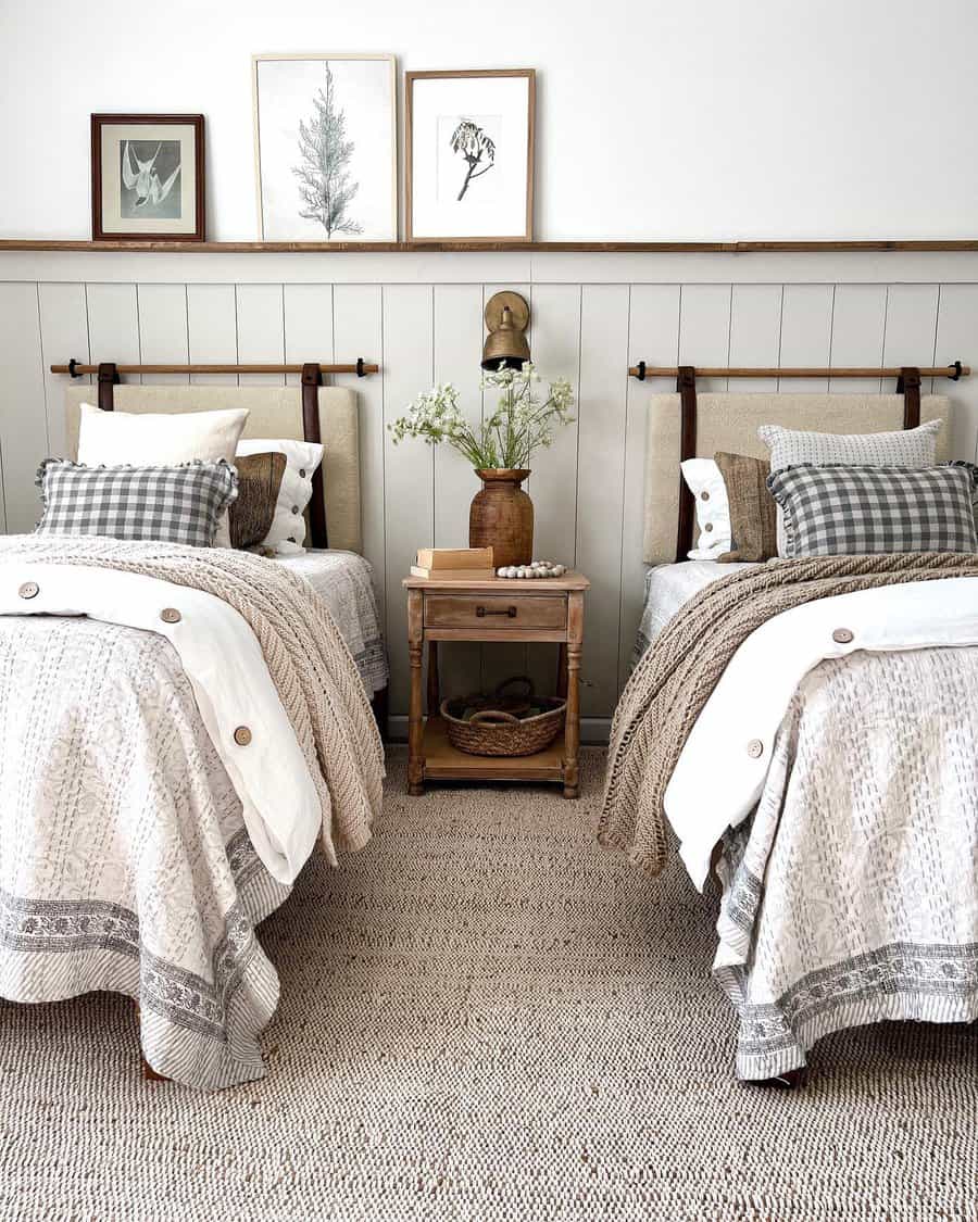 Twin beds in a cozy room with shiplap wainscoting and botanical prints