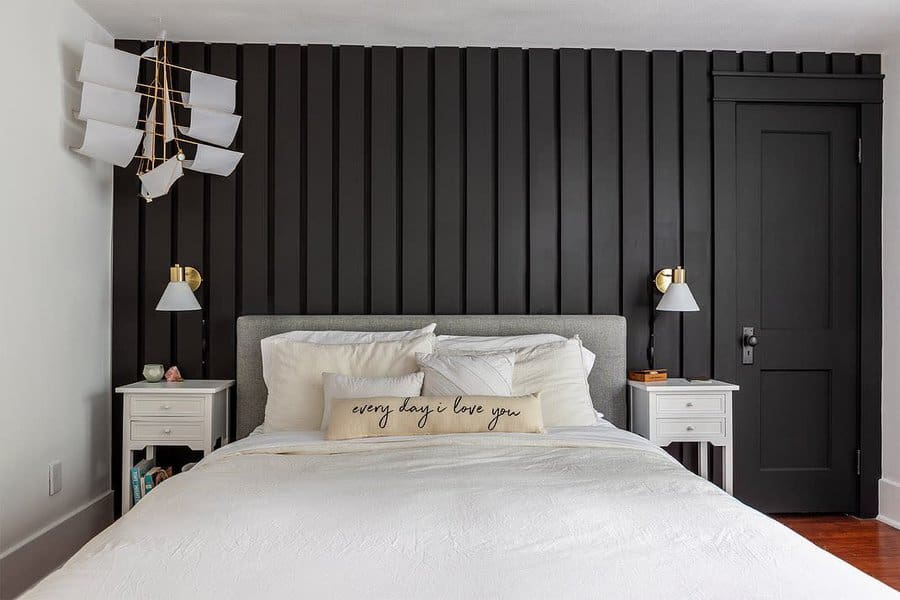 Elegant bedroom with vertical black paneling and chic chandelier