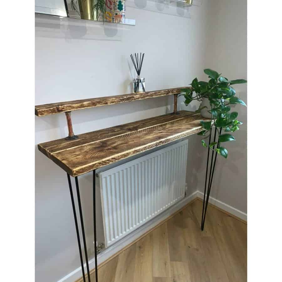 Compact rustic breakfast bar with a dark wood countertop, industrial pipe shelf, slim black metal legs, and a minimalist design perfect for small spaces