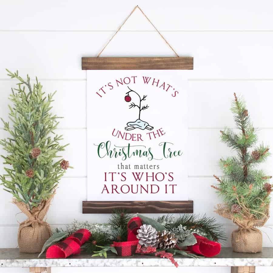 Festive sign with Christmas decor reading "It's who's around the tree that matters"