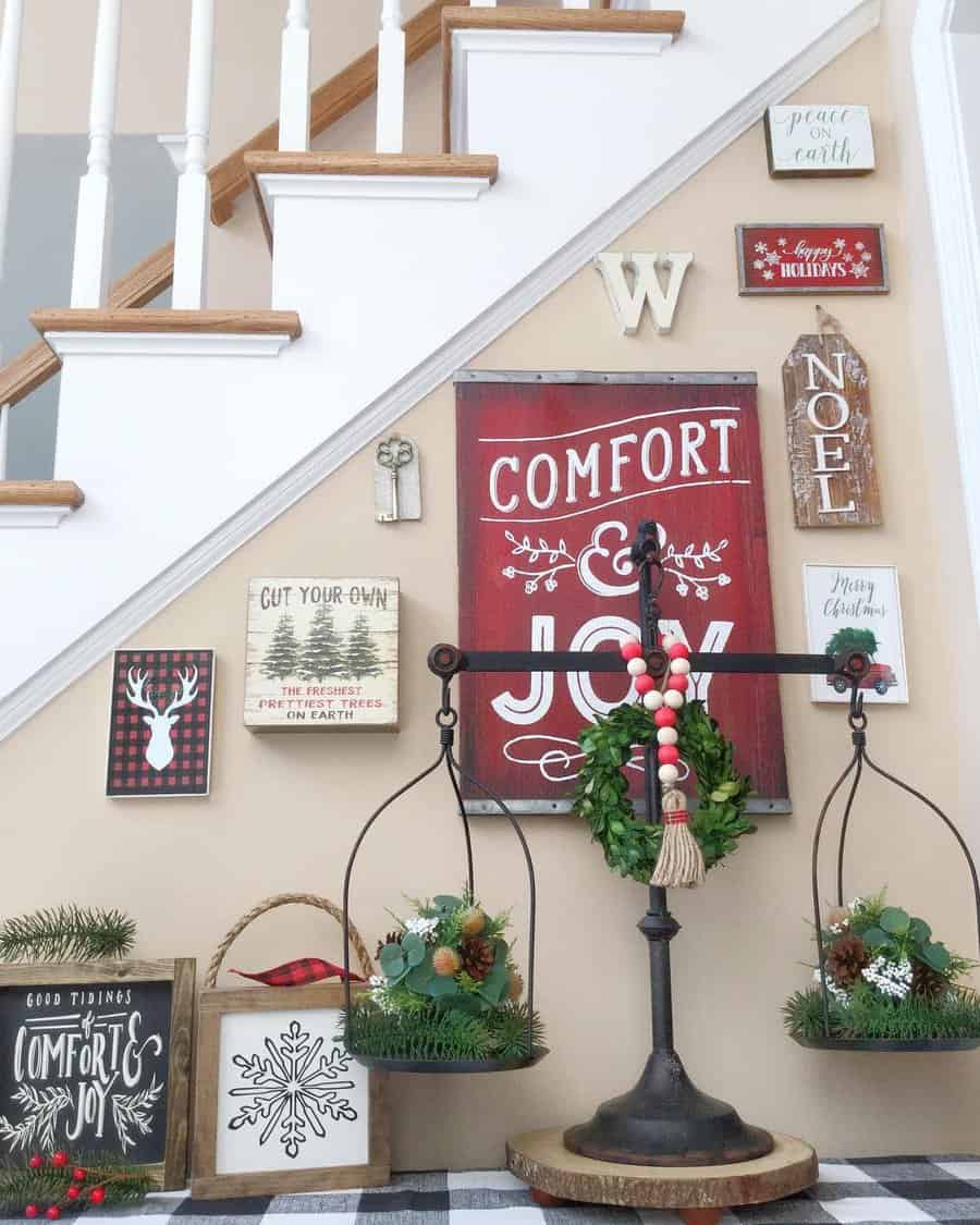 Rustic holiday decorations on a stairway wall with signs and festive greenery