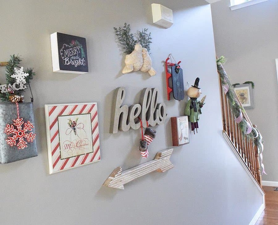 Decorative wall with holiday-themed artwork, a "hello" sign, and festive garlands