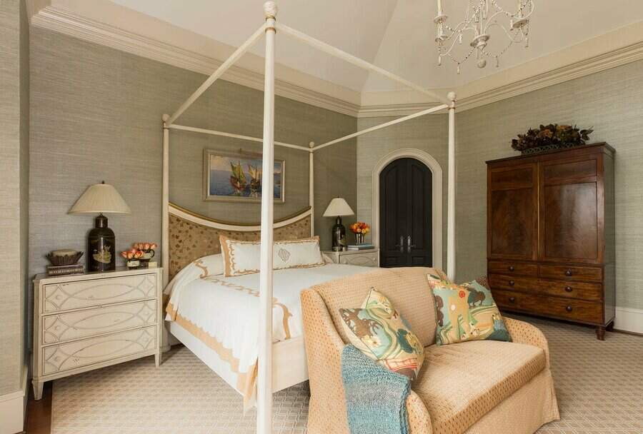 Elegant master bedroom with a four-poster bed, soft green walls, and classic furniture, creating a cozy and sophisticated retreat