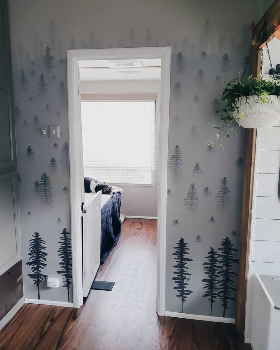 A charming RV hallway with forest-themed wallpaper featuring tall trees, adding a calming and nature-inspired element to the space.