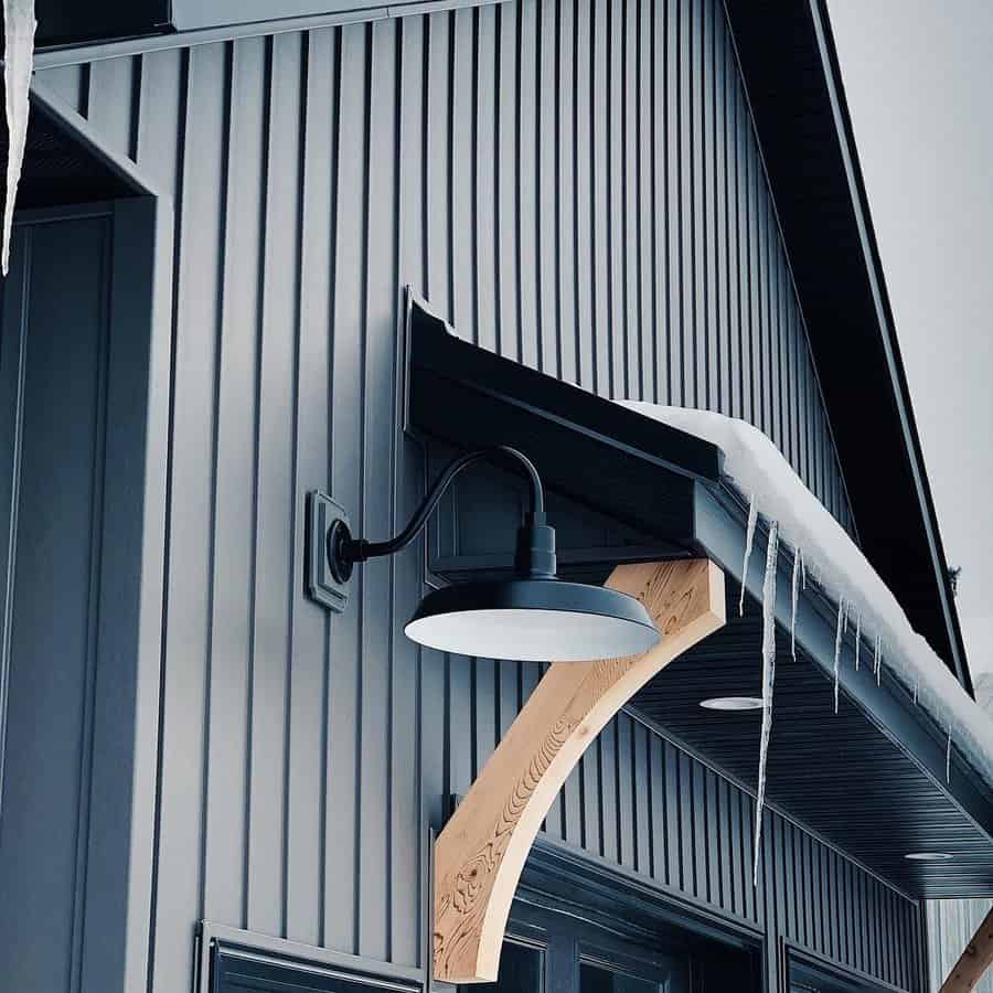 Outdoor wall light on a metal siding with icicles