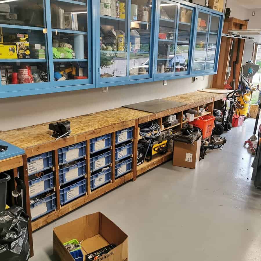 Long workbench with organized parts bins and overhead cabinets