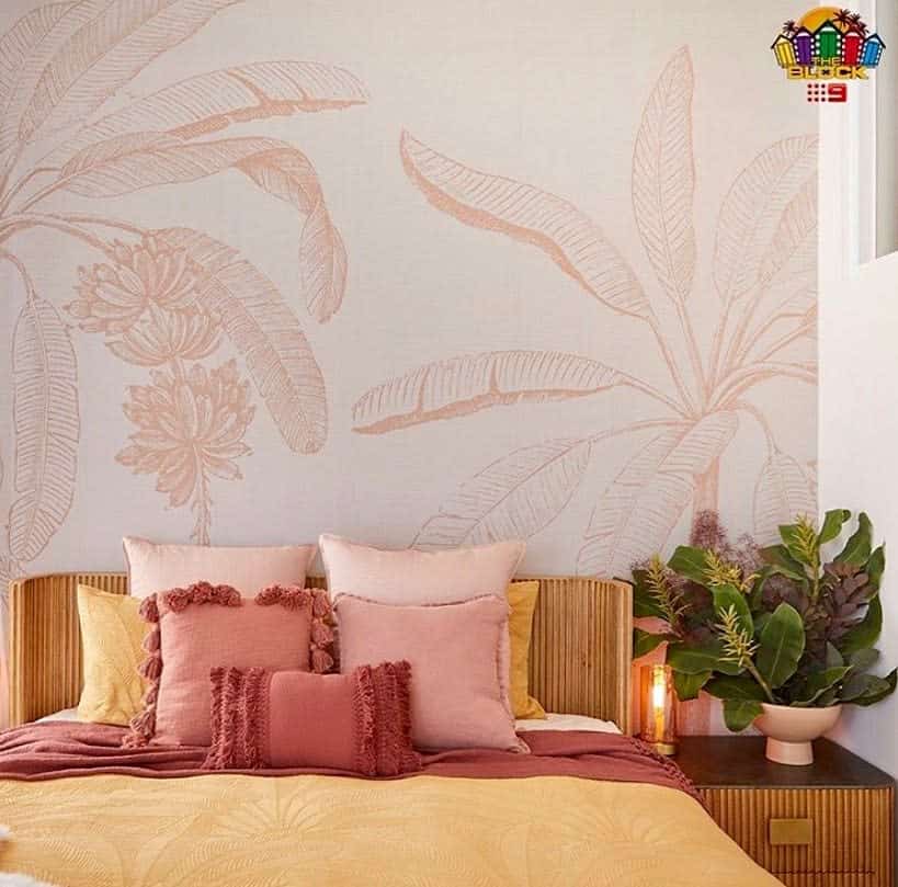 Warm bedroom with botanical mural and pink accents.