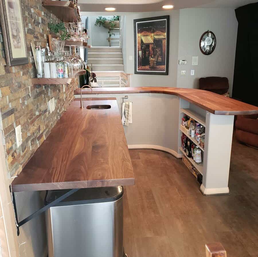 A kitchen wooden counter with a sink and refrigerator