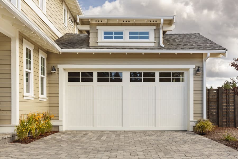 Craftsman style home with white garage door and paved driveway