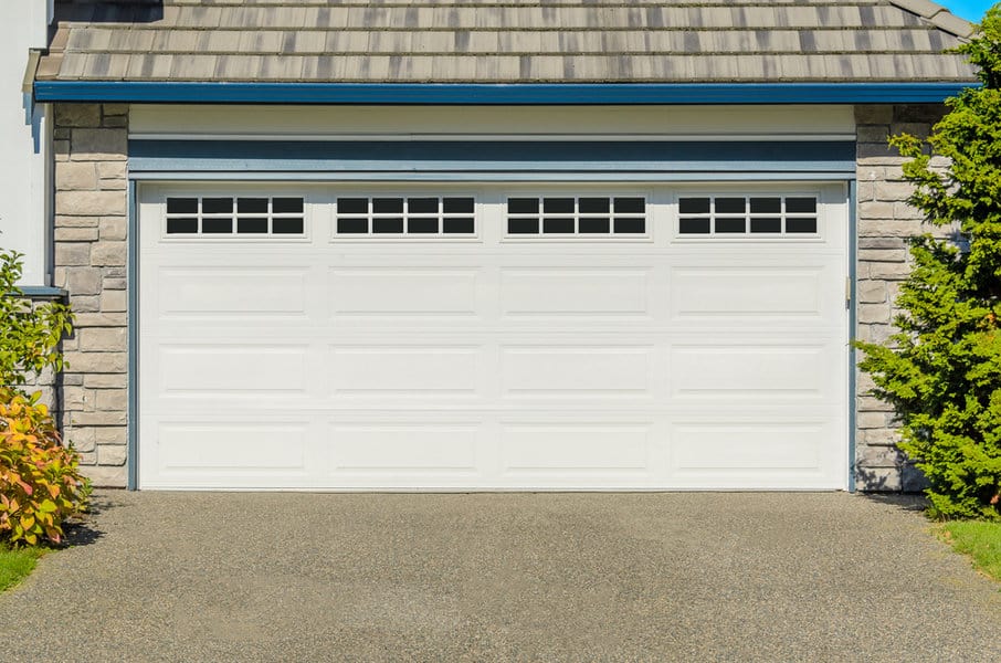 Rustic house with white wooden garage door and stone accents