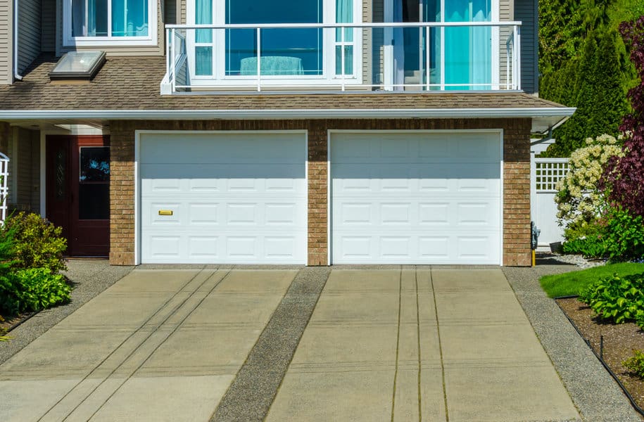 Rustic house with white wooden garage door and stone accents