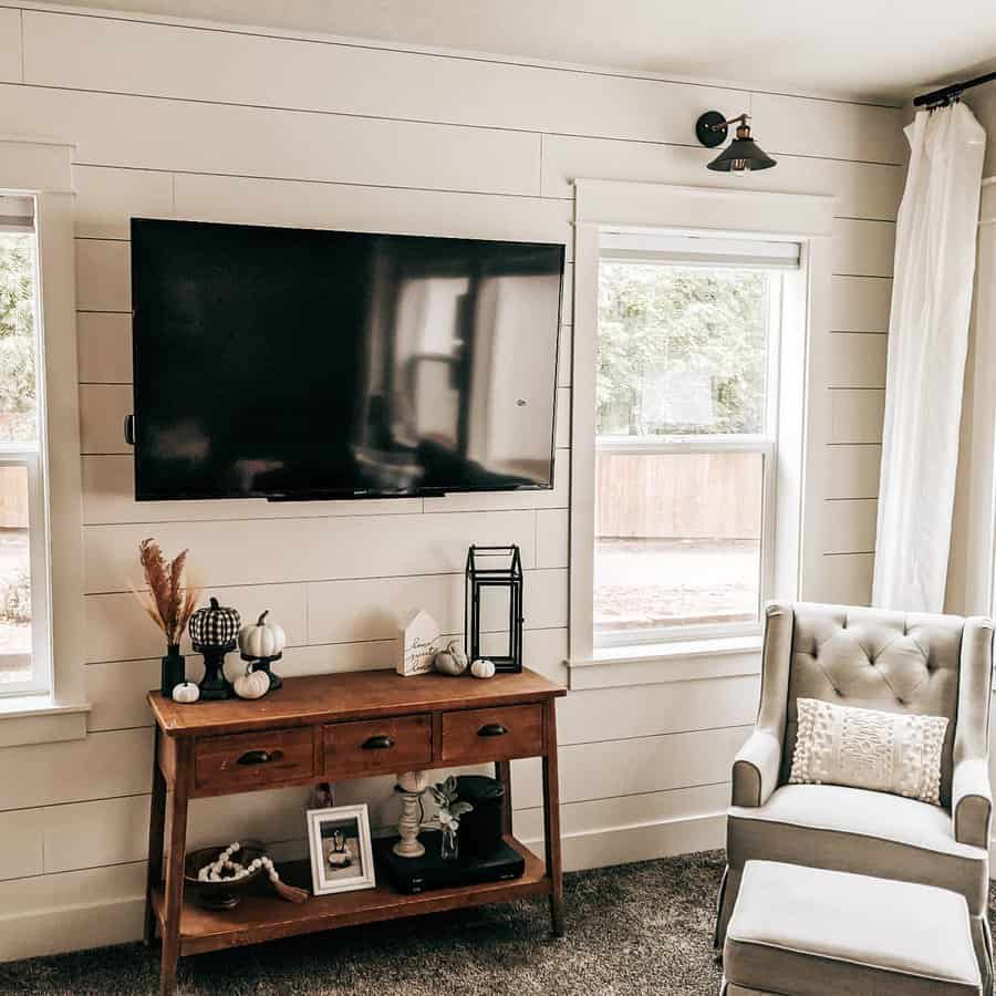 Living room with mounted TV on white shiplap wall and cozy decor