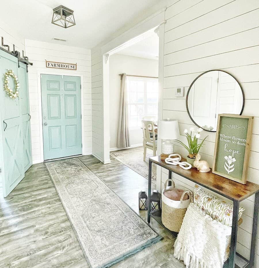 Entryway with white shiplap walls and light blue door