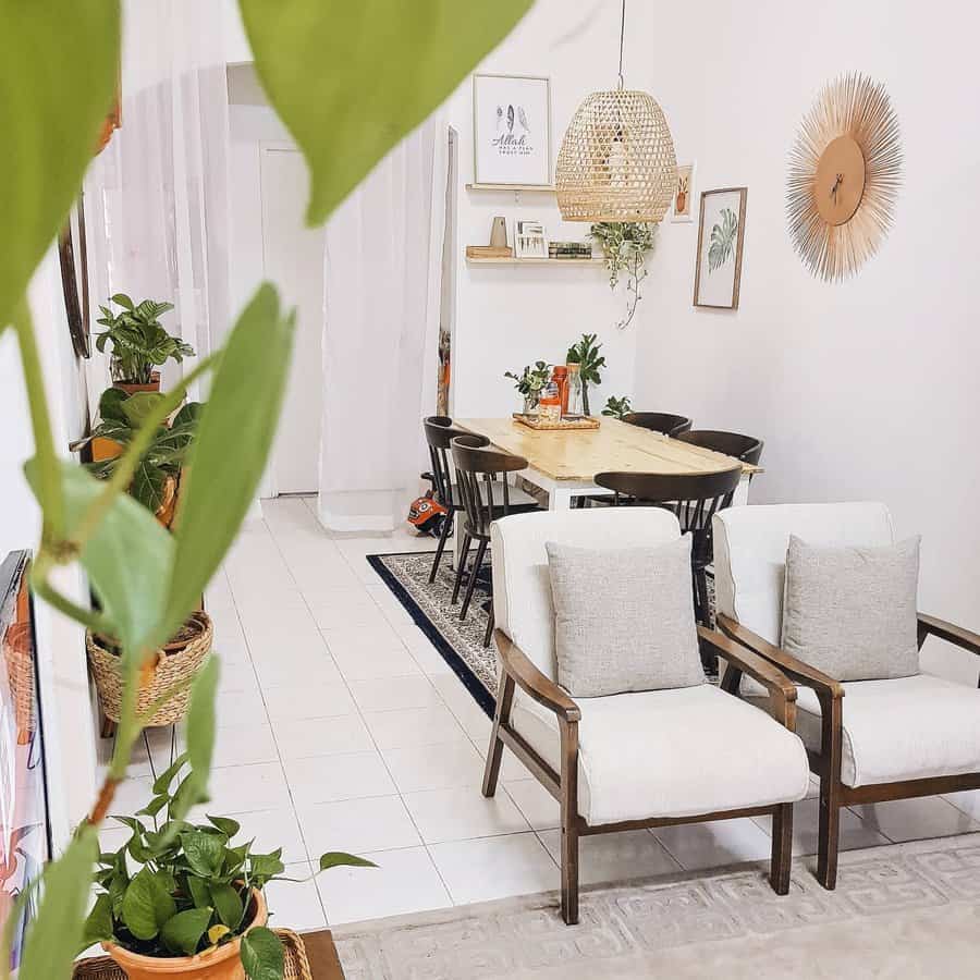 Bright living and dining room with white walls, wooden chairs, and a woven lampshade; potted plants add greenery to the space