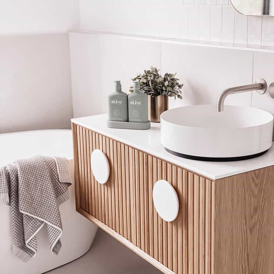 Minimalist vanity with ribbed wood detail and round mirror