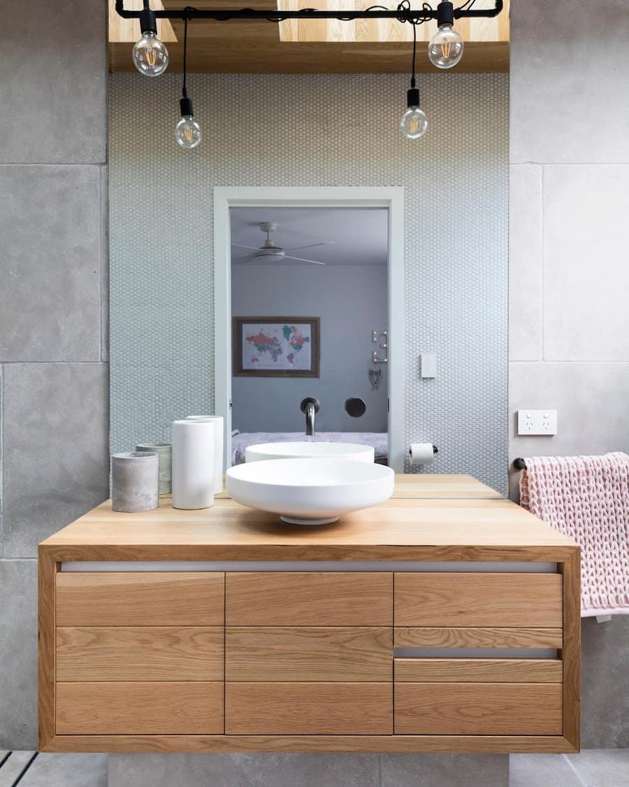 Sleek bathroom with oak vanity and pendant lights