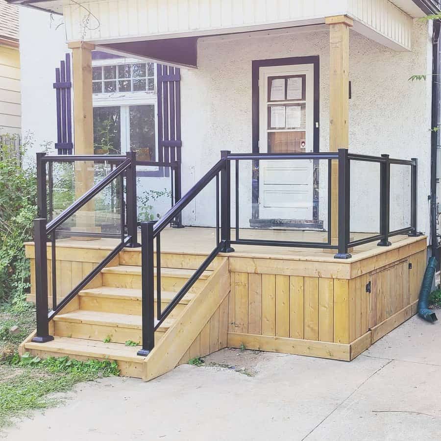 Front entry deck with black railings and wood skirting