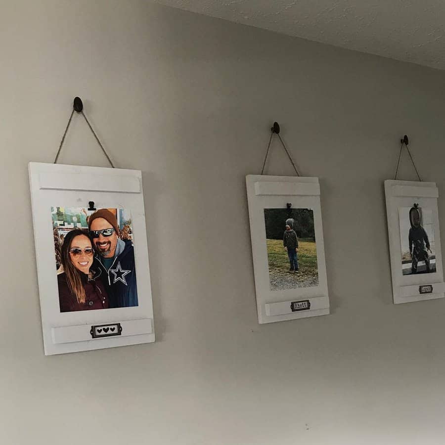 Three framed photos hanging on a wall: a couple smiling, a person walking outdoors, and a person standing in an open field