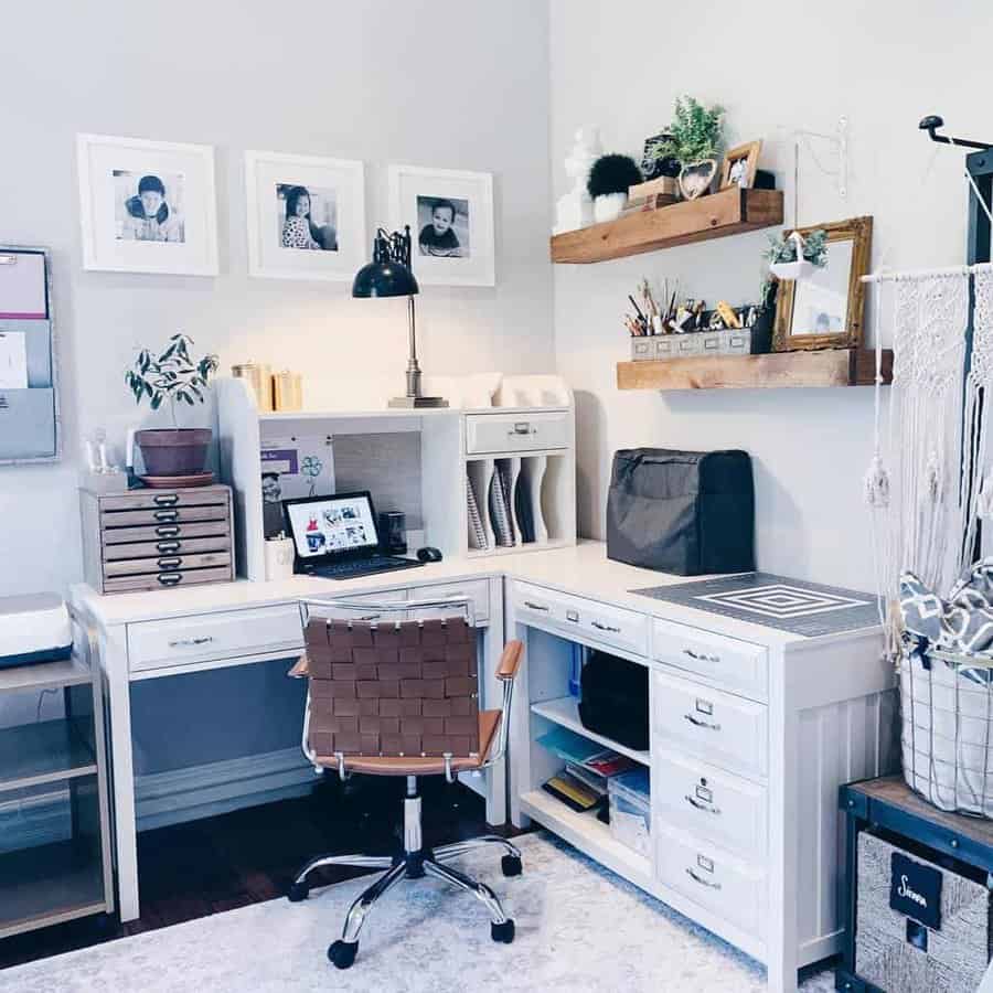 Stylish home office with wooden floating shelves, white cabinetry, framed photos, and organized workspace essentials for a cozy setup