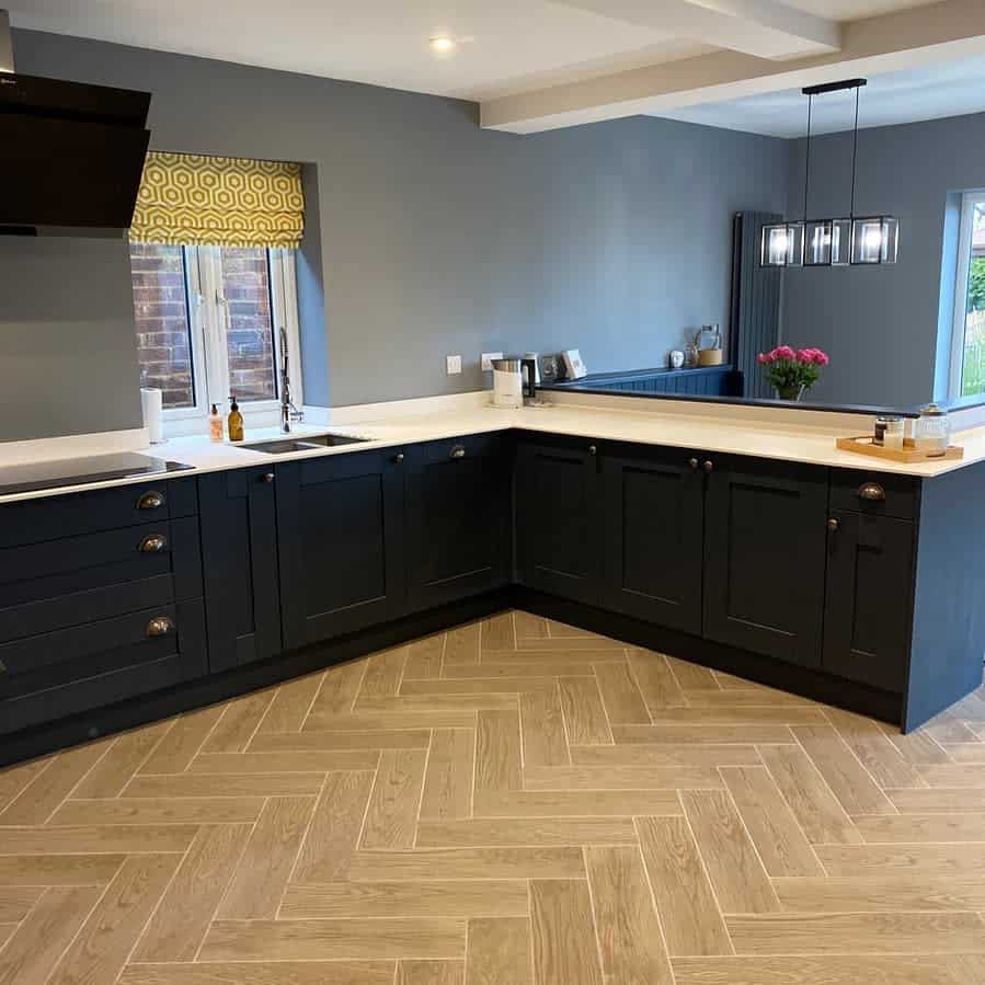 Elegant kitchen with navy cabinets and parquet tile flooring