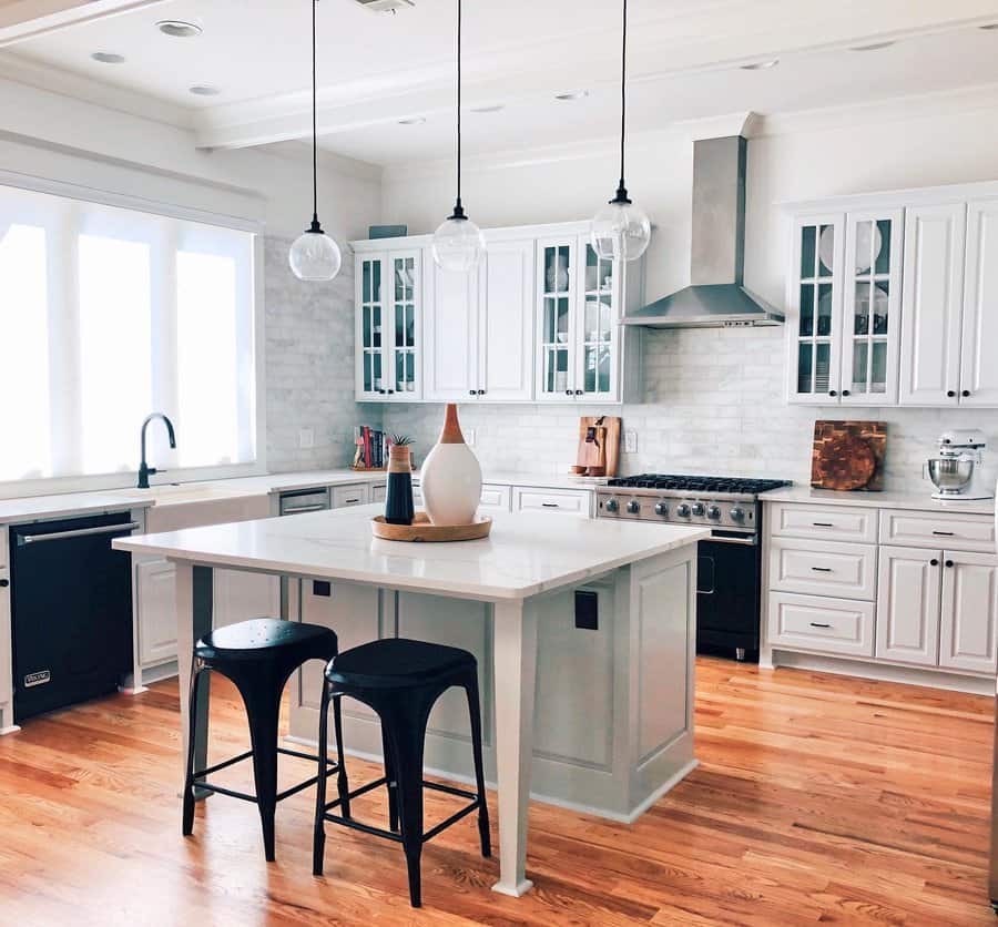 Bright kitchen with white island and wooden floor