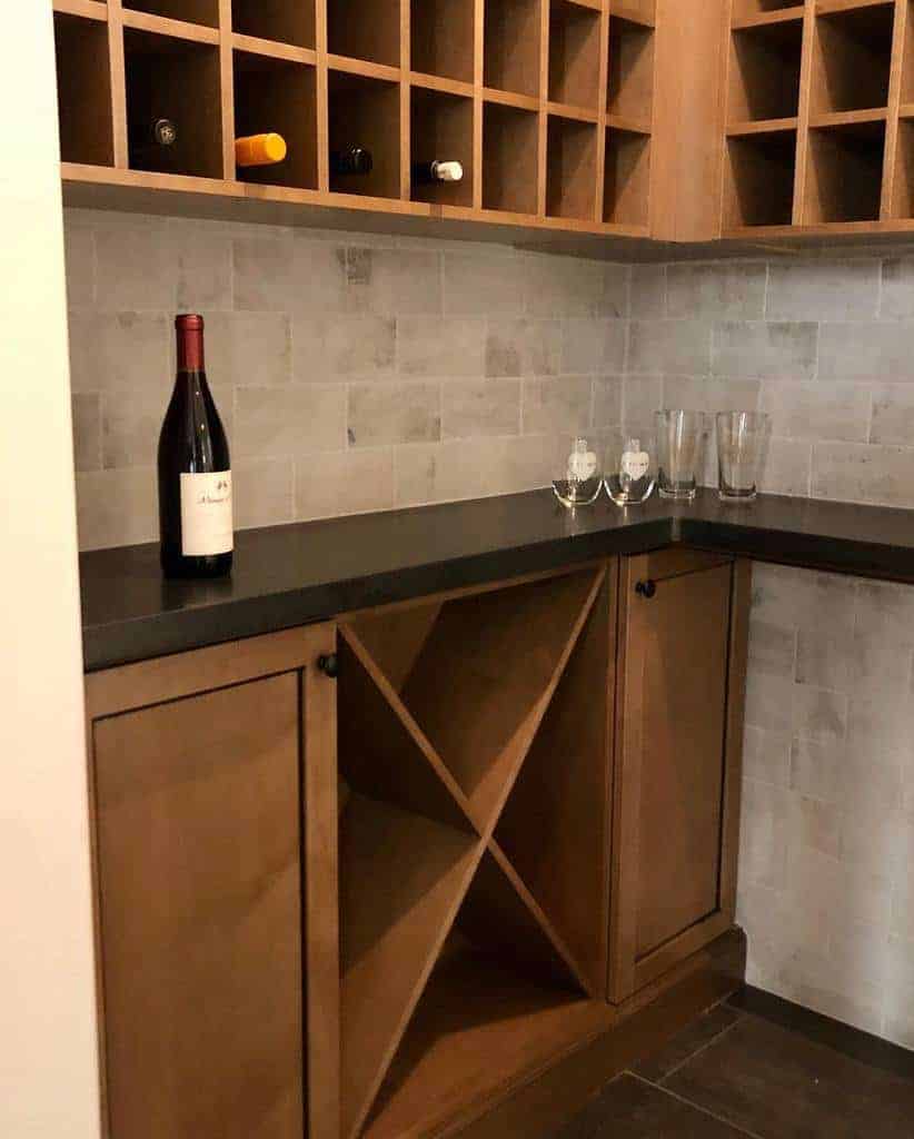 Warm wood wine storage with an X-shaped lower rack, upper cubbies, and a sleek black countertop for a stylish and functional bar area