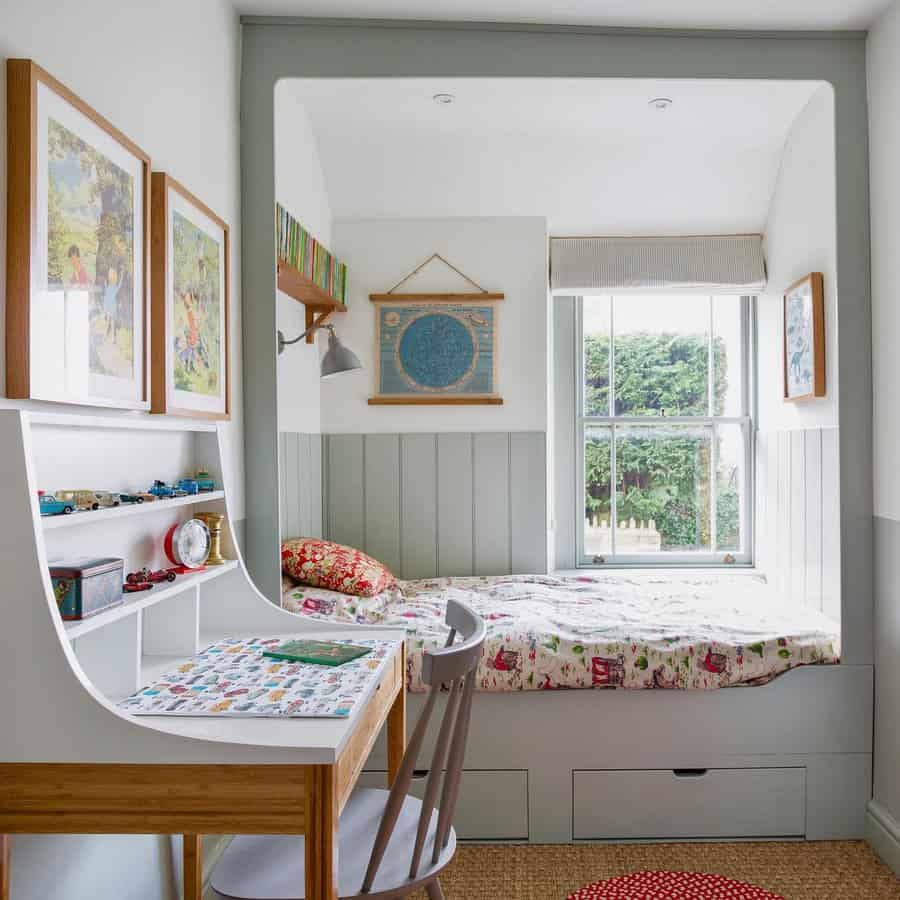 Child's room with a bed by the window, a desk with a chair, colorful bedding, and framed art on the walls; natural light fills the space