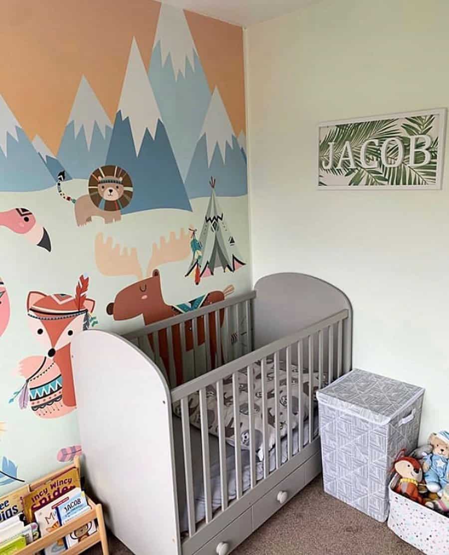 Nursery with a crib, animal-themed wall mural, a basket, and toys. A sign with "Jacob" hangs on the wall