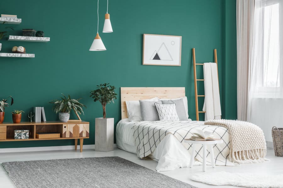 Stylish bedroom with dark teal wall and Scandinavian decor