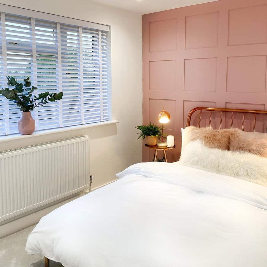 Modern bedroom with pink accent wall and white bedding