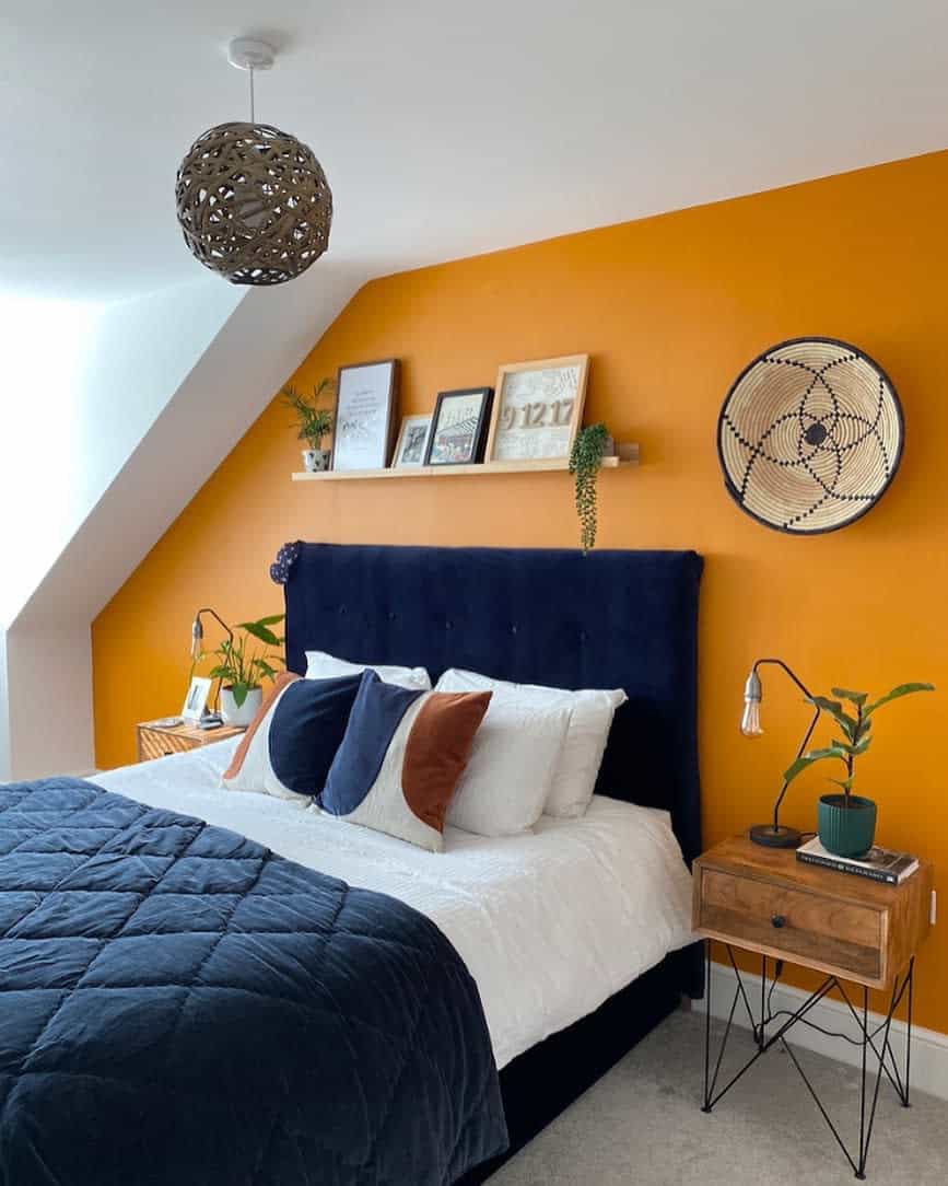 Attic bedroom with orange wall and navy headboard