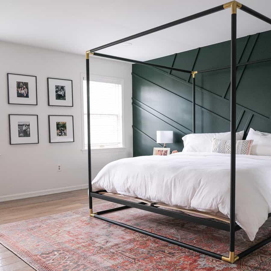 Chic bedroom with dark green panel wall and canopy bed