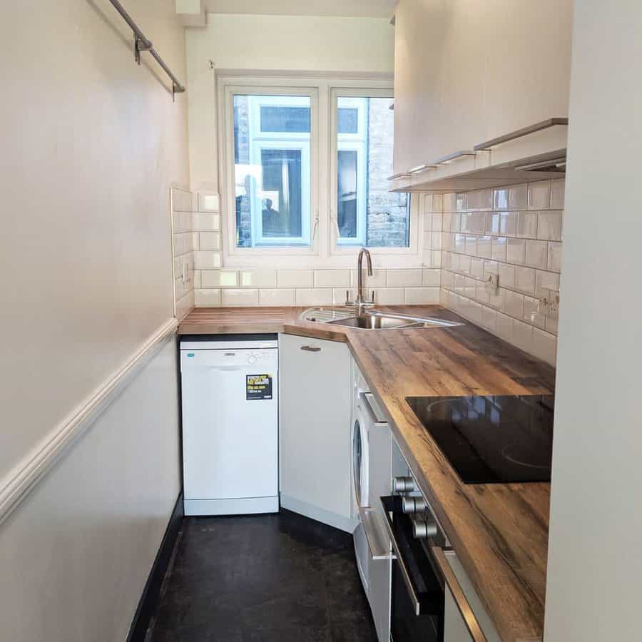 Narrow kitchen with wooden tops and white appliances