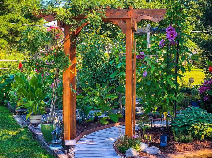 Wooden arbor with blooming flowers and garden pathway